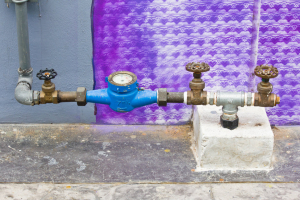 water supply main pipeline with meter against a Purple concrete
